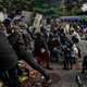 Protesters take cover behind homemade shields as they confront the police during a crackdown on demonstrations against the military coup in Yangon on March 16, 2021